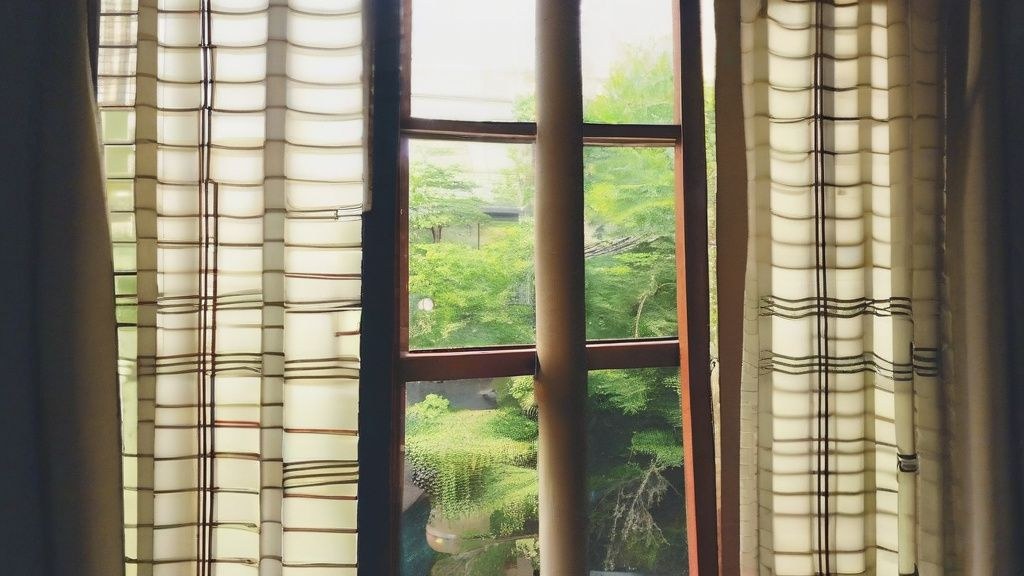 한국인 주부가 테이블에 앉아 작은 노트에 무언가를 적고 있는 모습